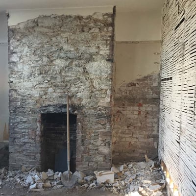 fireplace with plaster removed and a lath and plaster
