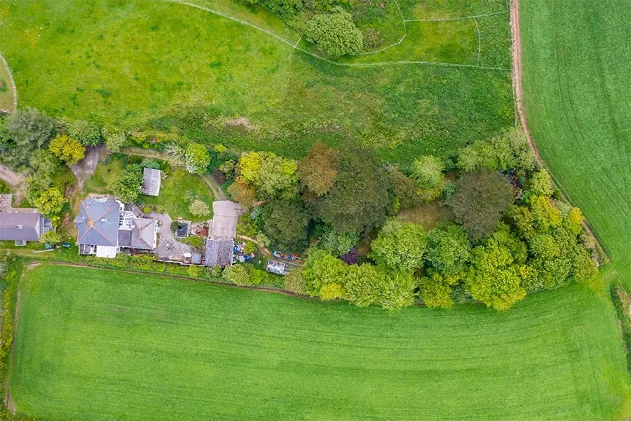 aerial view of cottage and outbuildings in the countryside