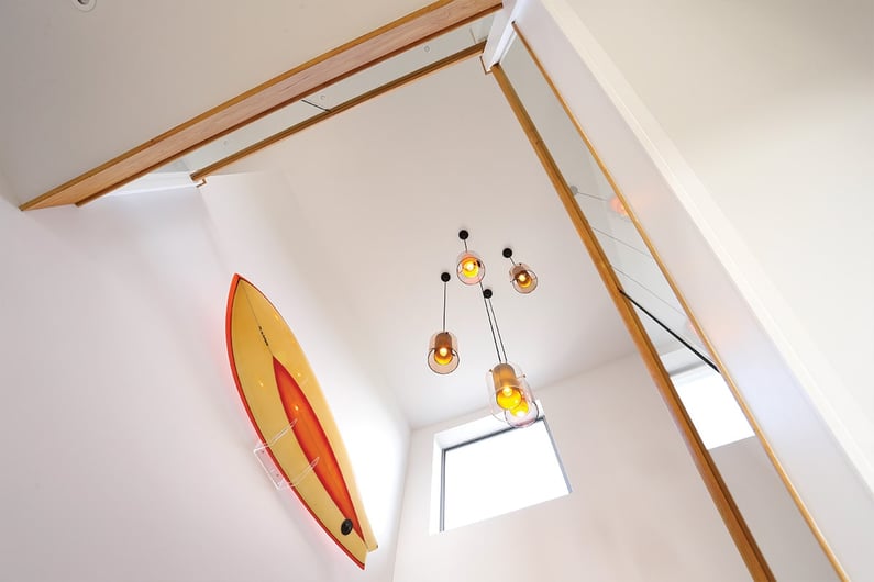 looking up at hanging light pendent and surfboard on the wall