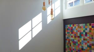 shadows cast on a white wall from light coming through the window