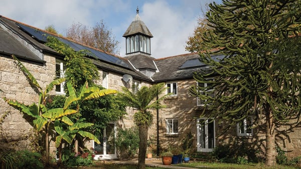external view of renovated farmhouse surrounded in lush greenery