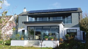 rear view of home with hung slate and white render