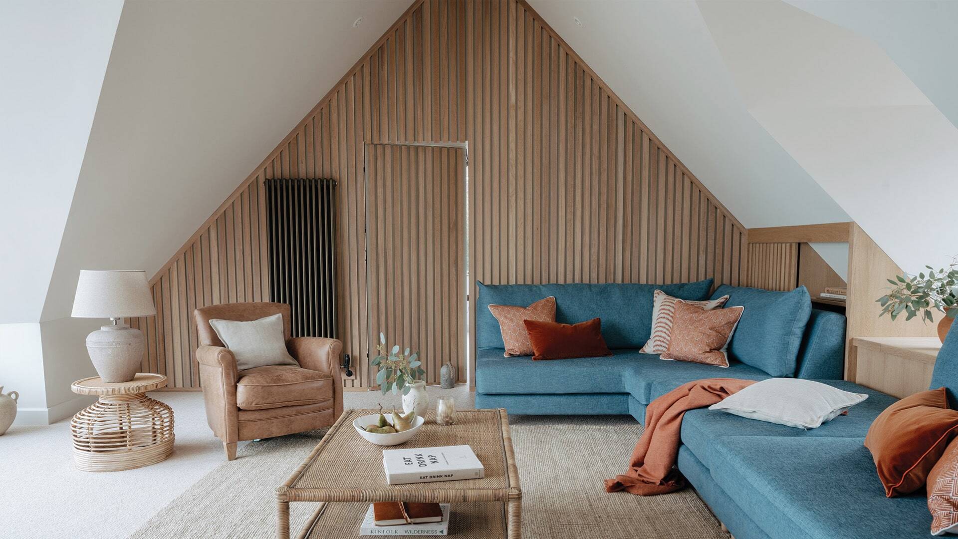living room with natural wood hidden door and blue sofa