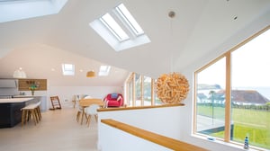 large circular steam bent wood light fitting with kitchen behind